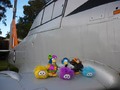 Three penguins and three puffles on an airplane wing.