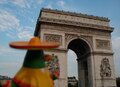 A Mexican-themed penguin in front of Arch of Triumph on France.